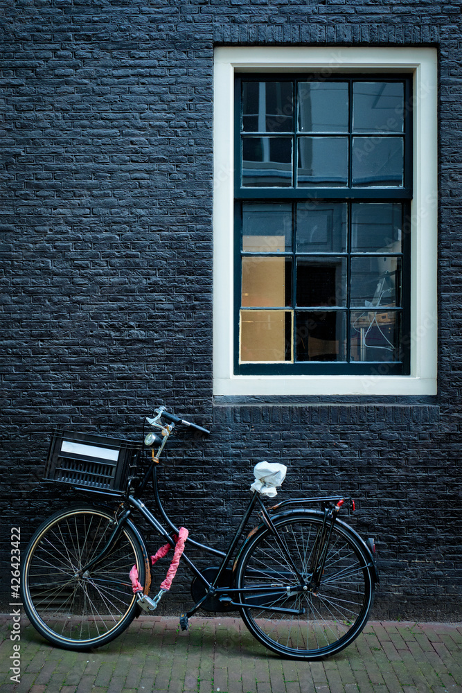 Bicycle near wall of old house in Amsterdam street