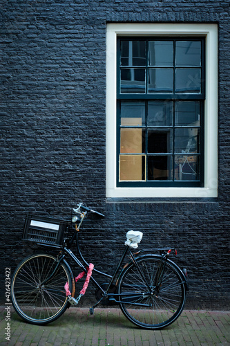 Bicycle near wall of old house in Amsterdam street
