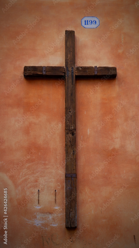 Wooden cross hanging on antique teal orange wall