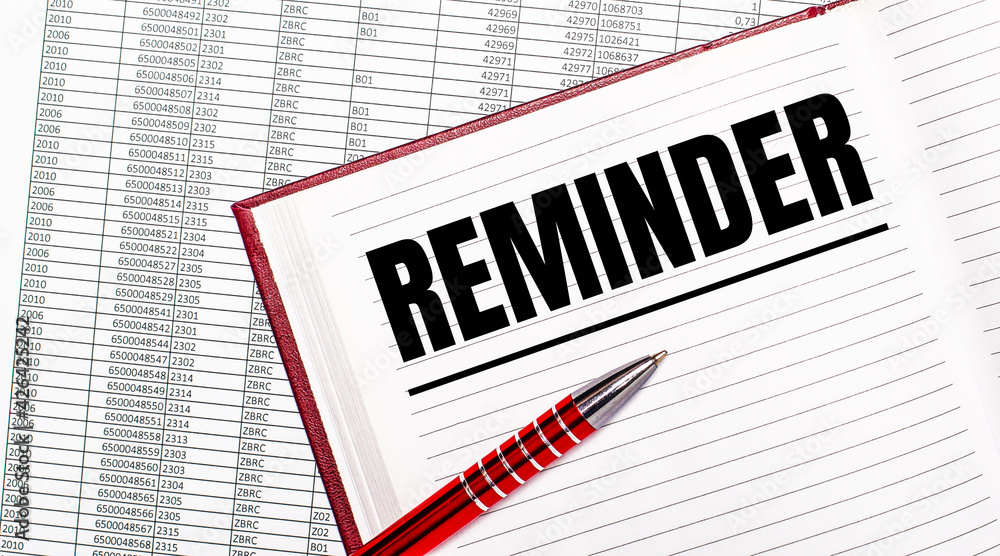 On the table next to the reports is a diary with the text REMINDER. Nearby is a red handle. On the table next to the reports is a diary with the text REMINDER. Nearby is a red handle.