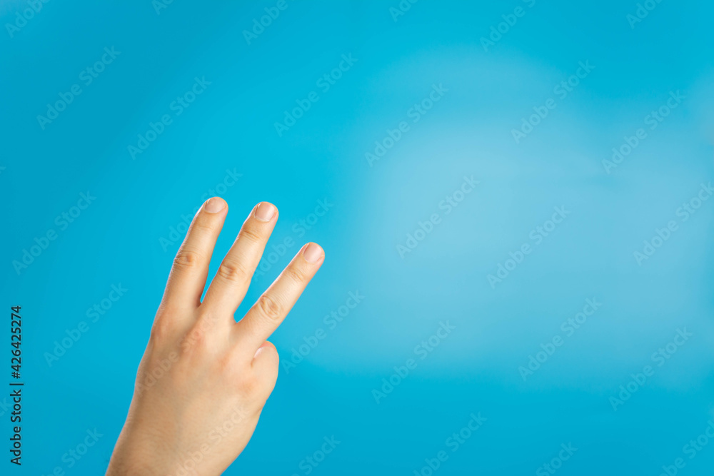 Hand of caucasian man showing fingers over isolated blue background counting number 3 showing three fingers. Hand sign on blue background. right hand a man show the third, number three sign