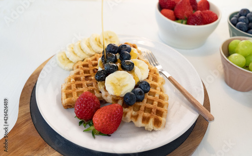 Delicious croffle dessert with fruits and maple syrup.