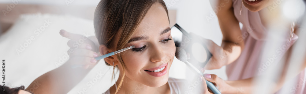 bridesmaids applying makeup on pretty bride, blurred foreground, banner. bridesmaids applying makeup on pretty bride, blurred foreground, banner.