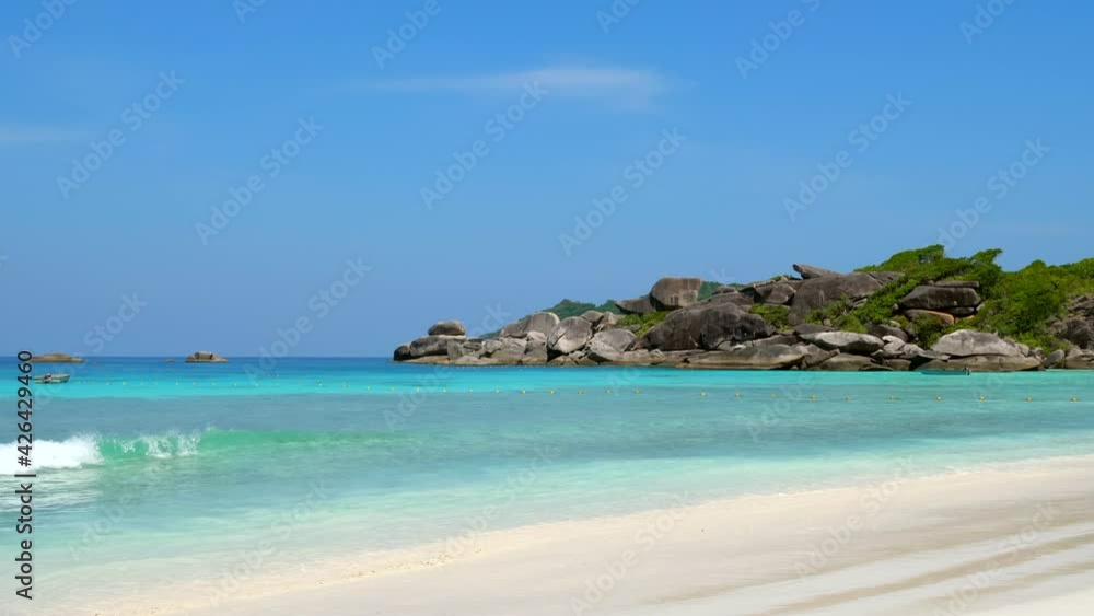 Sea Waves at Empty Sand Beach with Rocks and Blue Sky. Beach with Clear Turquoise Sea Water and Big Stones in Summer Day, Similan Islands, Thailand. Opening of Borders and Travel in Tropical Country Sea Waves at Empty Sand Beach with Rocks and Blue Sky. Beach with Clear Turquoise Sea Water and Big Stones in Summer Day, Similan Islands, Thailand. Opening of Borders and Travel in Tropical Country
