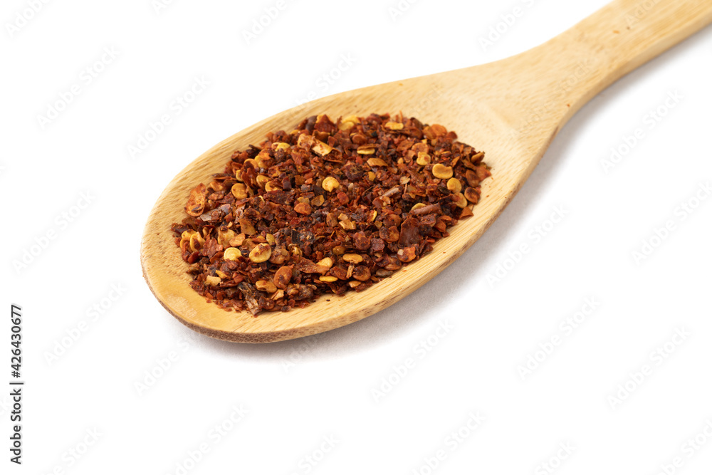 Closeup of dried calabrian chili pepper on a wooden spoon isolated over white background Closeup of dried calabrian chili pepper on a wooden spoon isolated over white background