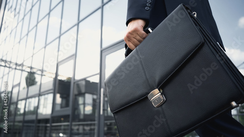 cropped view of businessman holding leather briefcase. photo