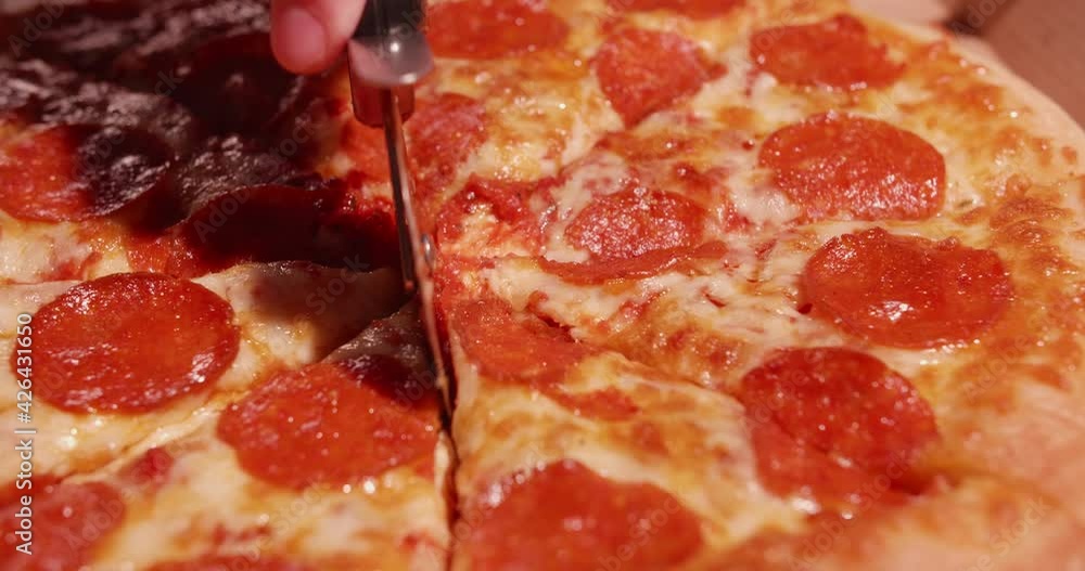 Slicing pizza for dinner macro shot Slicing pizza for dinner macro shot