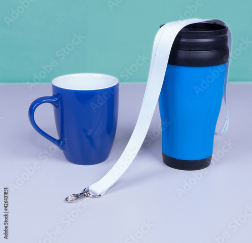 White Lanyard Neck Strap for mockup with thermo mug and ceramic mug . On grey desk office photo