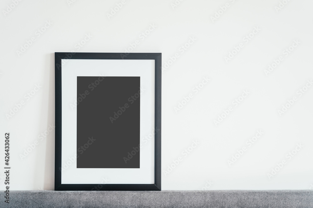 Blank wooden photo frame stands in the interior on a white background. Mockup poster frame close up in home interior. Blank wooden photo frame stands in the interior on a white background. Mockup poster frame close up in home interior.