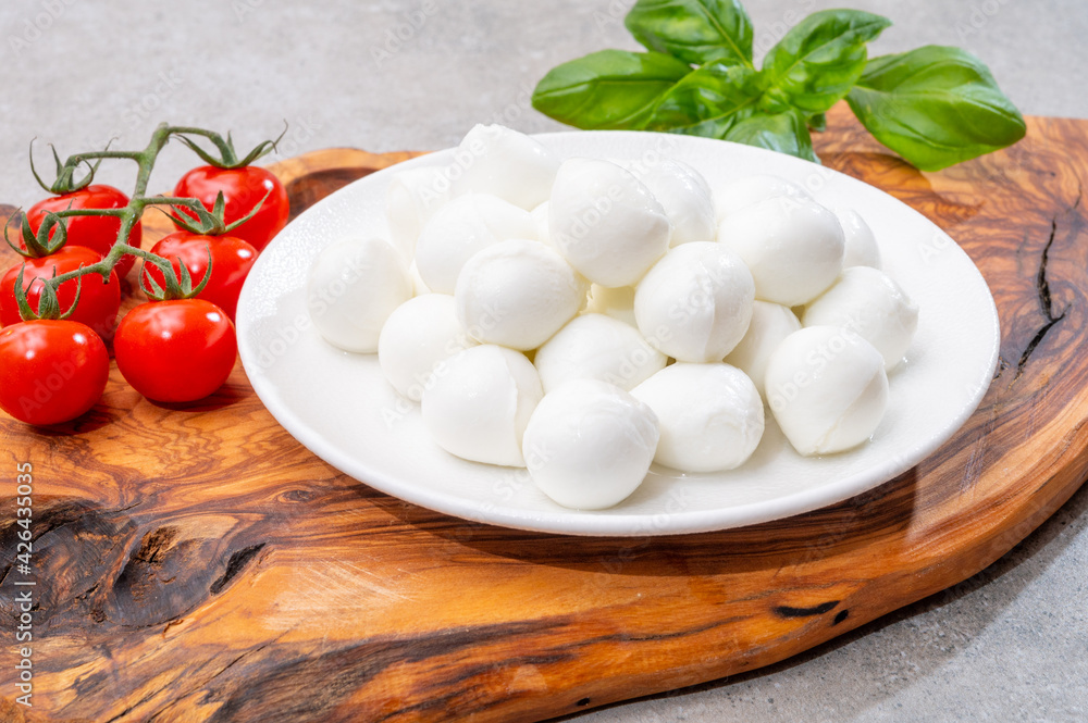Italian tricolore, small balls of fresh white soft Italian mozzarella cheese, ripe red cherry tomatoes and fresh green basil herb, ready for making caprese salad Italian tricolore, small balls of fresh white soft Italian mozzarella cheese, ripe red cherry tomatoes and fresh green basil herb, ready for making caprese salad