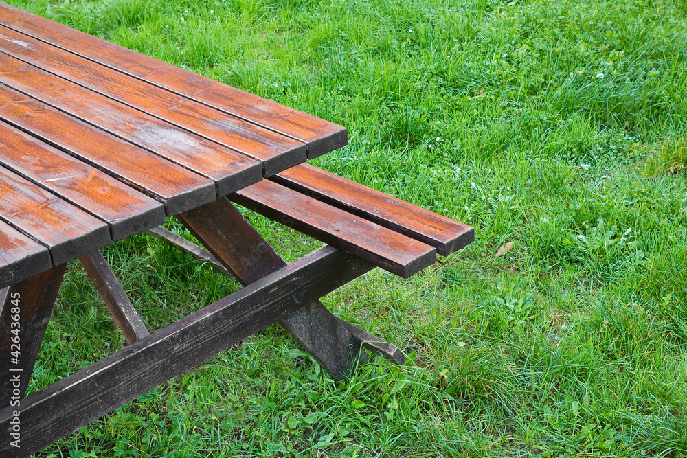 Wooden empty picnic table on a green meadow of a public park Wooden empty picnic table on a green meadow of a public park