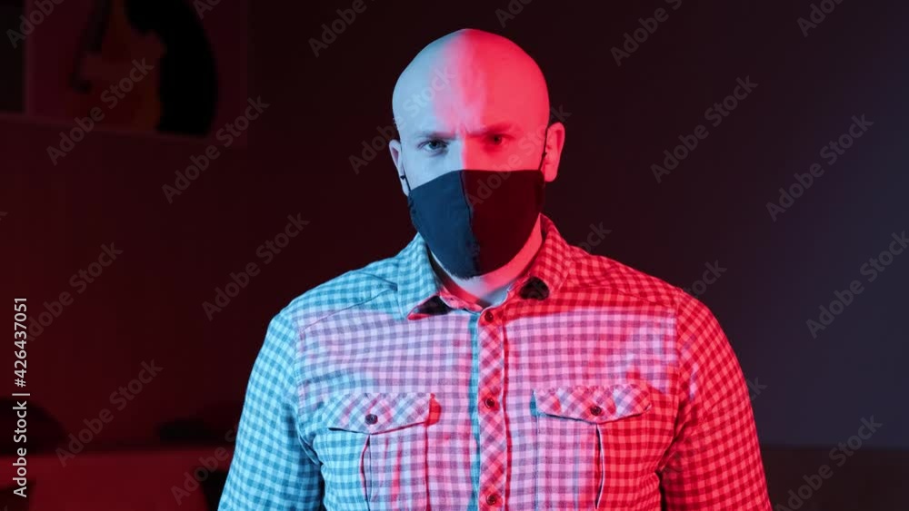 Man with protective medical mask,looking at camera, flashing red, blue light. Man with protective medical mask,looking at camera, flashing red, blue light.