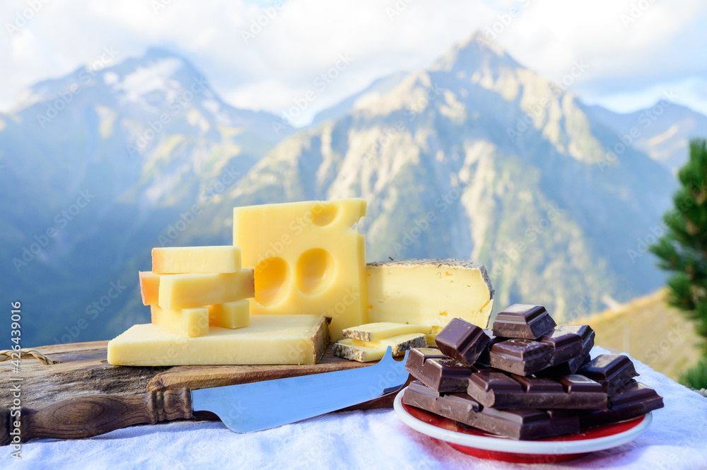 Tasty Swiss cheeses and dark pure chocolate, emmental, gruyere, appenzeller served outdoor with