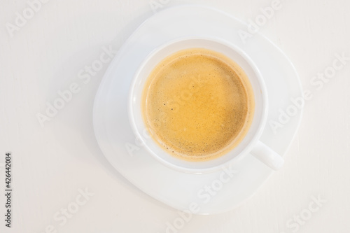 Close up top view of a white porcelain cup of coffee isolated on white background