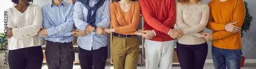 Diverse business people and coworkers holding hands standing in row together. Team of multiethnic male and female employees supporting each other and showing corporate unity. Teamwork concept. Banner
