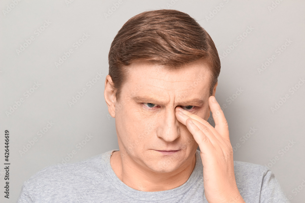 Portrait of serious thoughtful mature man rubbing his eye with hand Portrait of serious thoughtful mature man rubbing his eye with hand