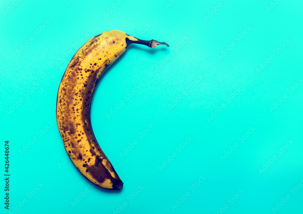 Ripe banana on a blue background. Overripe banana. Ripe banana on a blue background. Overripe banana.