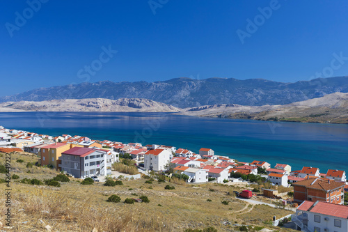 Panoramic view of Pag city with Velebit mountains on horizon on sunny summer day, Adriatic sea, Croatia