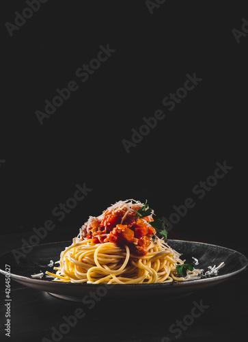 Traditional pasta spaghetti bolognese in plate on black wooden table background