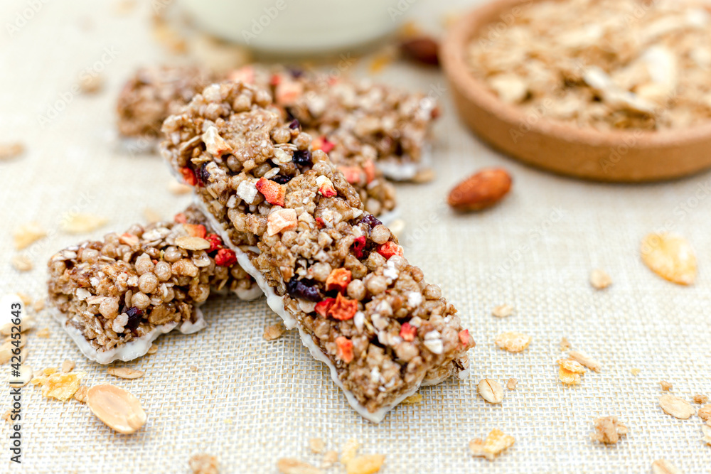 Granola Healthy Snack Bars Granola cereal bar with nuts and berries with yogurt on Sackcloth background Granola Healthy Snack Bars Granola cereal bar with nuts and berries with yogurt on Sackcloth background