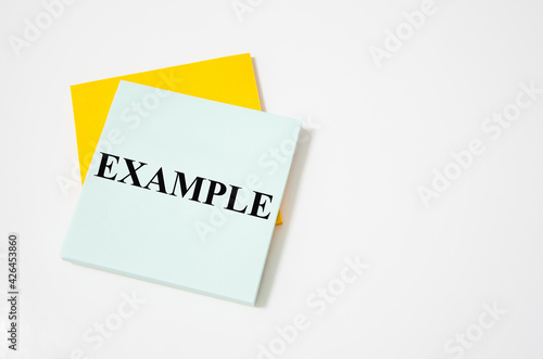 Example text written on a white notepad with colored pencils and a yellow background
