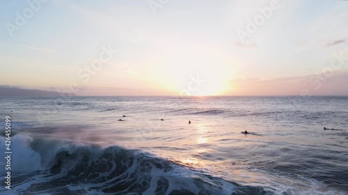 Surfers at sunset, O'ahu North Shore Hawaii Pacific Ocean, 4K aerial view