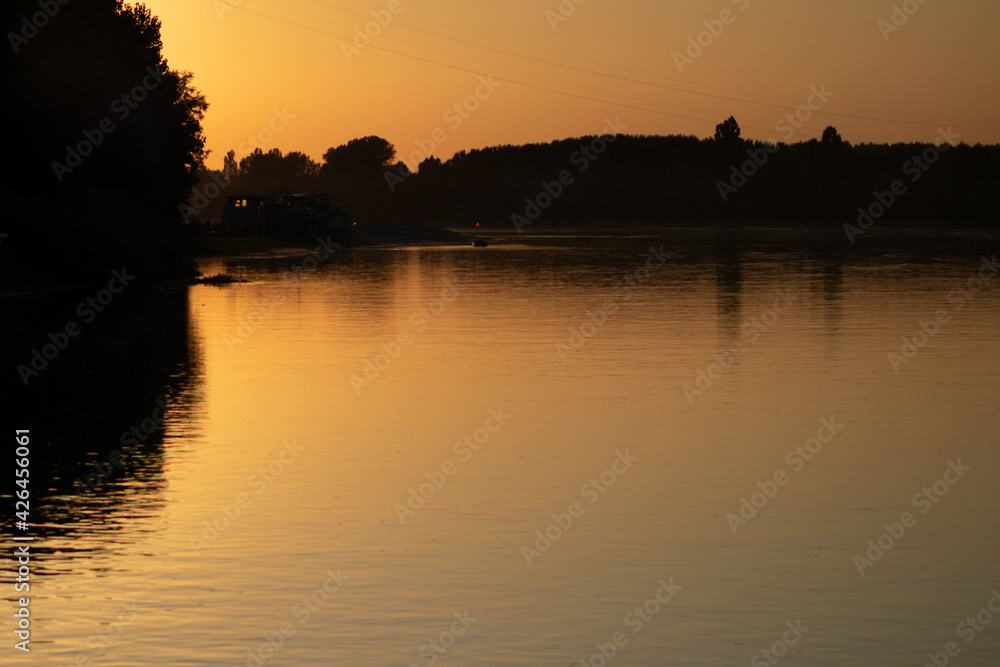 Sunset reflections in the water of the Po river, Italy