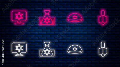 Set line Jewish money bag, kippah, Star of David and Hanukkah dreidel. Glowing neon icon on brick wall. Vector