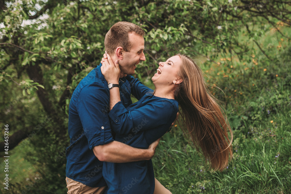 Fototapeta premium Portrait of a happy couple have fun in the spring garden. Strong family relationships of a couple in love