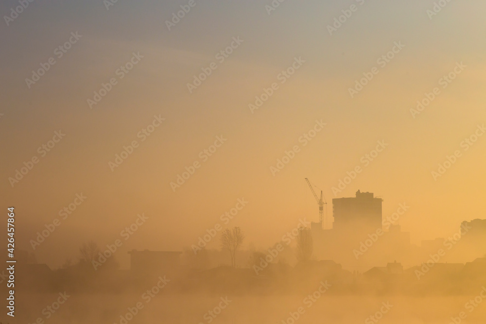 Fog over the city. Misty morning in the city