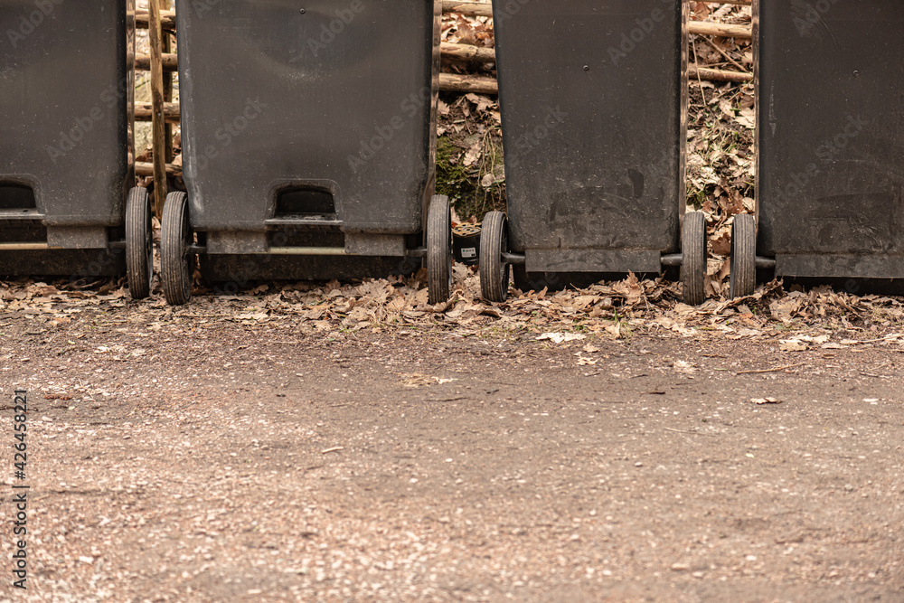 Four grey garbage cans on wheels.. Four grey garbage cans on wheels..