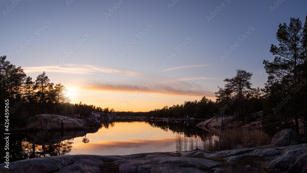 Panorama view of sunset in the Swedish archipelago. Rocks, calm water and coastal features this tranquil evening. Photo taken outside Oskarshamn, Sweden Panorama view of sunset in the Swedish archipelago. Rocks, calm water and coastal features this tranquil evening. Photo taken outside Oskarshamn, Sweden