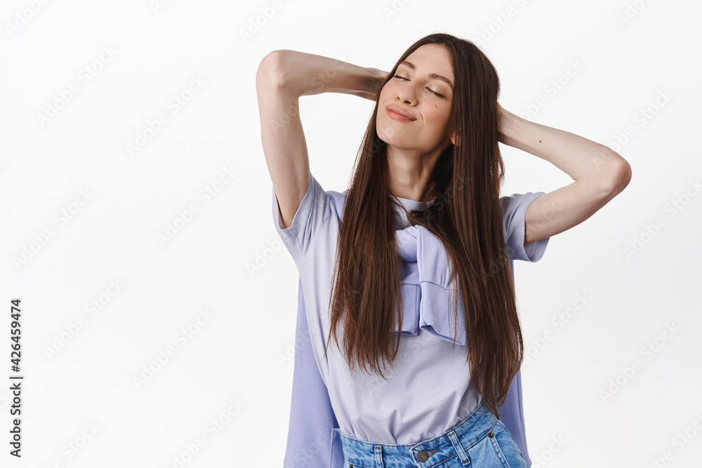 Image of brunette woman enjoying sun, resting with hands behind head, clsoe eyes and smile pleased, relaxing, having perfect weekend, vacation or leisure time, standing over white background Image of brunette woman enjoying sun, resting with hands behind head, clsoe eyes and smile pleased, relaxing, having perfect weekend, vacation or leisure time, standing over white background