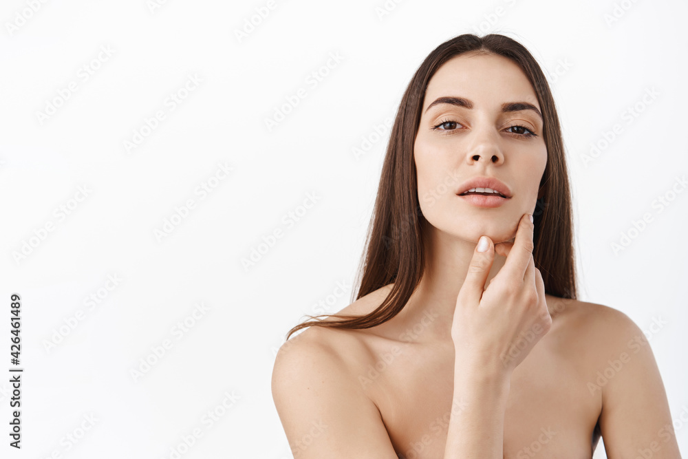 Beauty face. Woman with natural makeup and healthy skin portrait. Beautiful female model touching fresh glowing hydrated facial skin on white background closeup. Skin care concept Beauty face. Woman with natural makeup and healthy skin portrait. Beautiful female model touching fresh glowing hydrated facial skin on white background closeup. Skin care concept