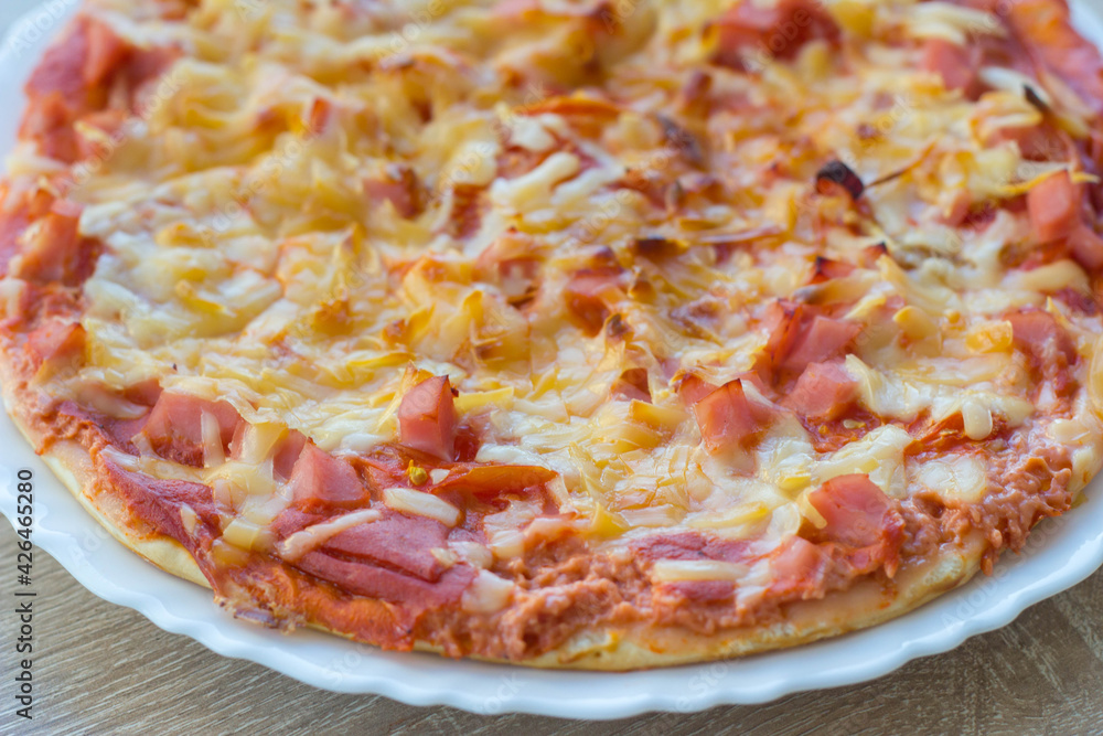ham and cheese pizza sits on a white plate ham and cheese pizza sits on a white plate