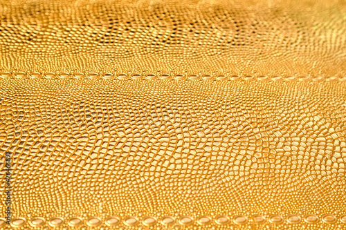 Golden glossy texture. Metal pattern. Golden texture of snake scales. Abstract gold background