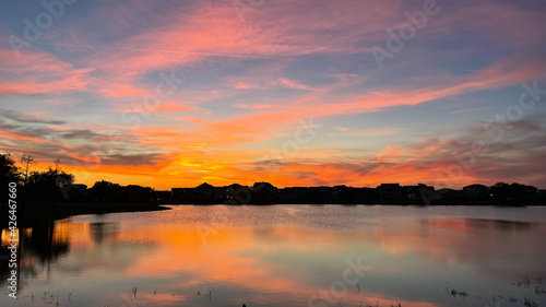 Beautiful pink, orange and blue sunset reflecting on a lake © Joni
