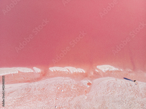 The surface of a pink lake with islands of salt. Top-down view.