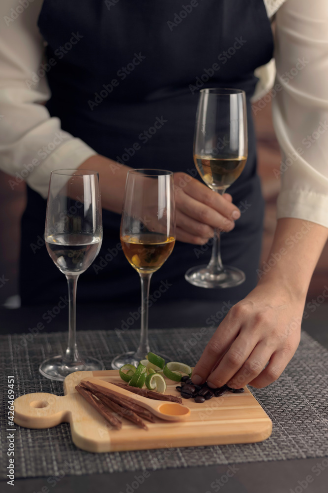 Catado de tequilas blanco, reposado y añejo. Mujer mexicana sosteniendo una copa de tequila añejo y un grano de café. Catado de tequilas blanco, reposado y añejo. Mujer mexicana sosteniendo una copa de tequila añejo y un grano de café.