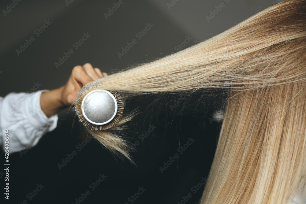 Fototapeta premium Hairdresser straightening client's dyed hair