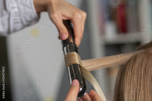 Hair stylist making curls with styling iron