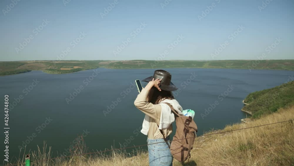 Back view of female traveler with backpack using modern smartphone for taking photos of amazing nature at Bakota area. Concept of people, technology and weekends. Back view of female traveler with backpack using modern smartphone for taking photos of amazing nature at Bakota area. Concept of people, technology and weekends.