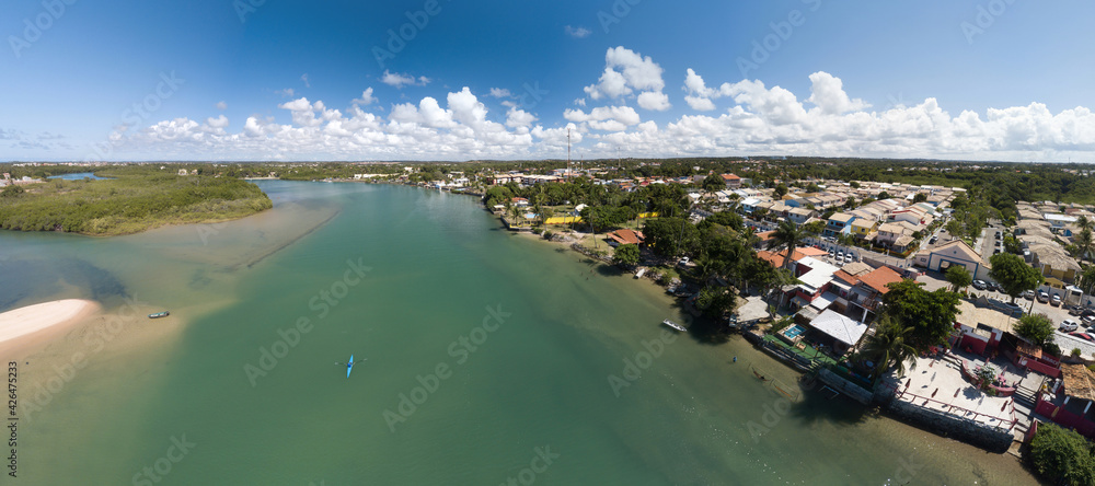 Fototapeta premium Vista panorâmica da Barra do Jacuípe, praia localizada no litoral do município de Camaçari, na Bahia, Brasil, Imagem capturada acima do rio Capivara