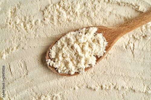 Photography Whey protein powder on a wooden spoon, top view