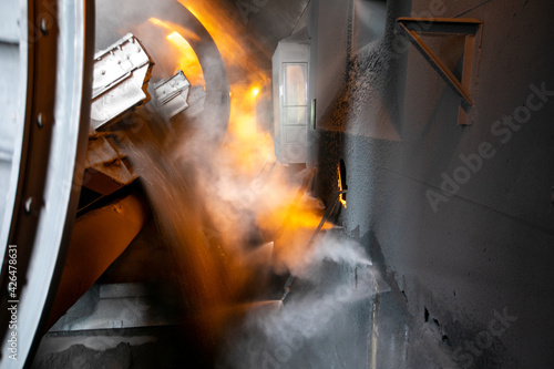 Large coal port. Close-up. A car with coal is overturned in a closed coal transshipment building. Coal is poured out of the car.