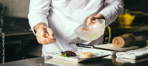 the chef decorates a plate of foie gras