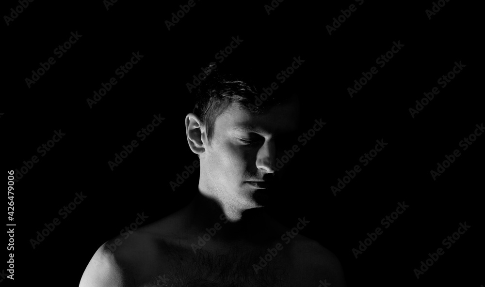 black and white photo portrait of a guy, in dramatic lighting