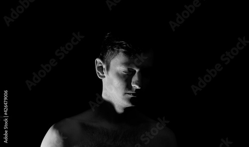 black and white photo portrait of a guy, in dramatic lighting