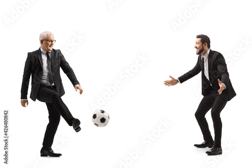 Full length profile shot of two businessmen playing football