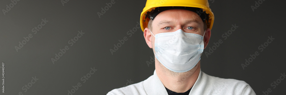 Male construction worker in yellow caste and medical protective mask. Male construction worker in yellow caste and medical protective mask.
